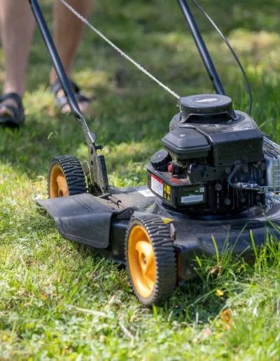 Man using a push mower to cut grass